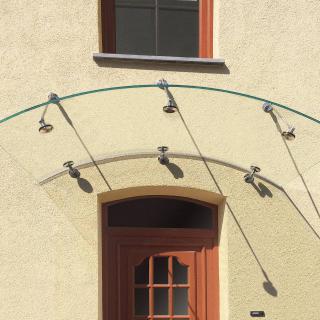 Gebogenes Glasvordach Arcata An Sandfarbener Hausfassade