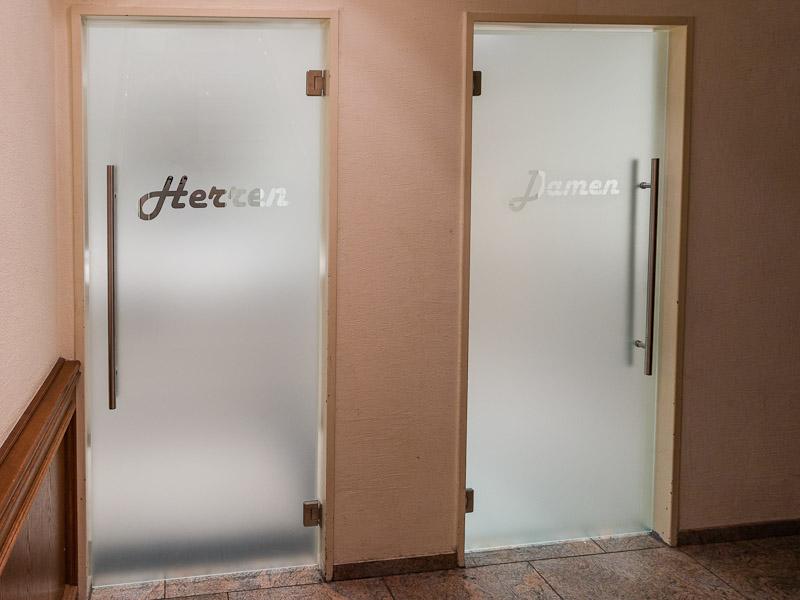 schwenktueren-aus-glas-fuer-toiletten-im-hotel