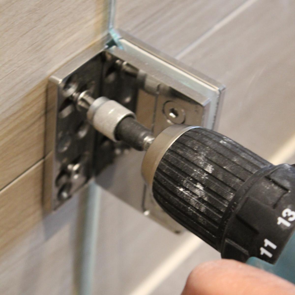 Festschrauben des Wand-Glas-Scharniers an der Dusche